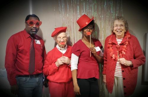 4 people dressed up in red with props